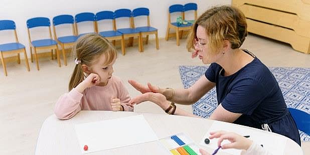 Kvinne og barn i barnehage i samspill om tegning.