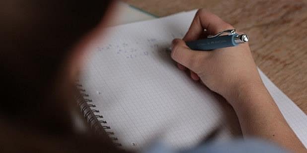 Illustrasjonsfoto av hånd som holder penn mot papir