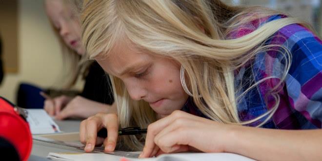 Ilustrasjonsfoto av jente i et klasserom som strever med et matematik-stykke.