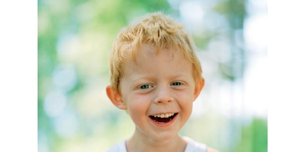 En liten gutt som smiler. Foto.