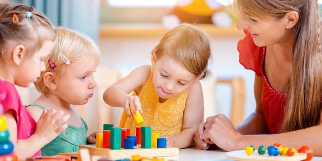 35868304-group-of-children-and-teacher-playing-in-kindergarten.jpg