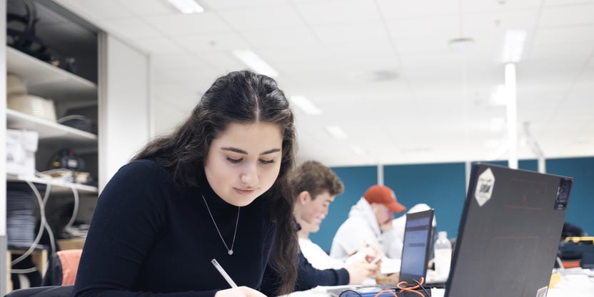 Klasserom med elever, jente i fokus ved PC, yrkesfag, elektrofag