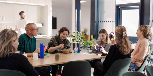 Bildet viser lærere ved Oksenøya barneskole. Vi er inne i lærerværelset, hvor det er lunsjpause. Det er god stemning og lærerne smiler.