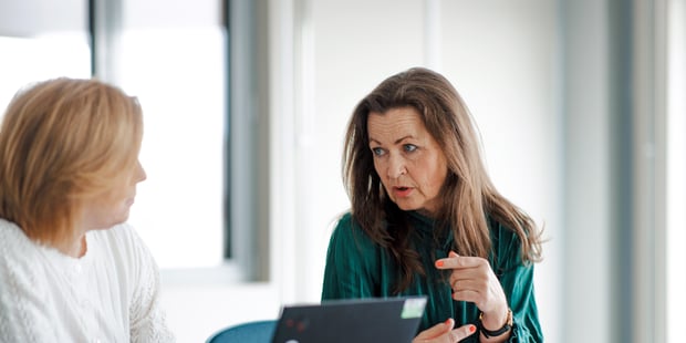 to kvinner diskuterer ved et arbeidsbord