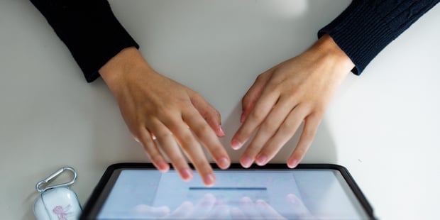 Bildet viser en elev på Eineåsen ungdomsskole 2024 som jobber med en oppgave på en ipad. Bare hendene synes.