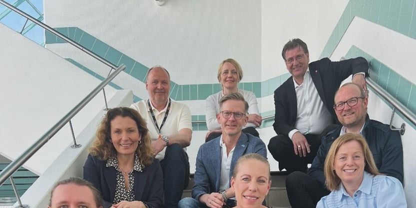9 personer sitter i en trapp