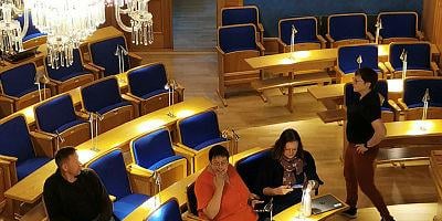 Bilde av mennesker som diskuterer i bystyresal
