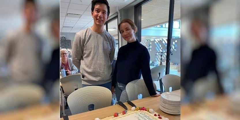 Lars Tsujimoto Frengstad og Maya Rønning Lindseth står og ser på en stor kake med påskriften "Gratulerer til medlem nr. 16500 i Trøndelag"