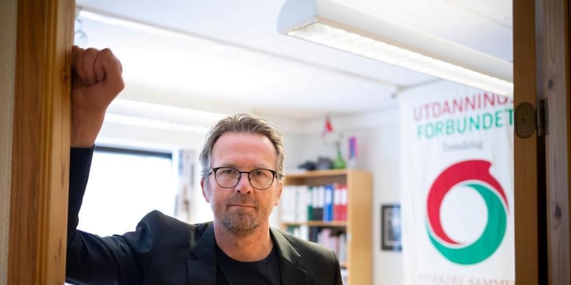 Fylkesleder i Trøndelag, Geir Røsvoll står i døråpning. Kontor med Utdanningsforbundets fane med logo i bakgrunnen. Foto.