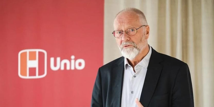 Spesialrådgiver Erik Orskaug i Unio står foran en rød Unio-fane og ser mot kameraet.