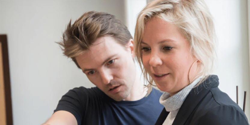 En mann og en kvinne ser på skjermen på en bærbar PC