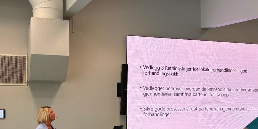 Fylkesstyremedlem og kontaktperson for medlemmer i de videregående skolene, Mett H. Meedby foreleser for deltakere på kurs. Bakerst i bildet skjerm med Overskriften "Vedlegg 3. Retningslinjer for lokale forhandlinger - God forhandlingsskikk"