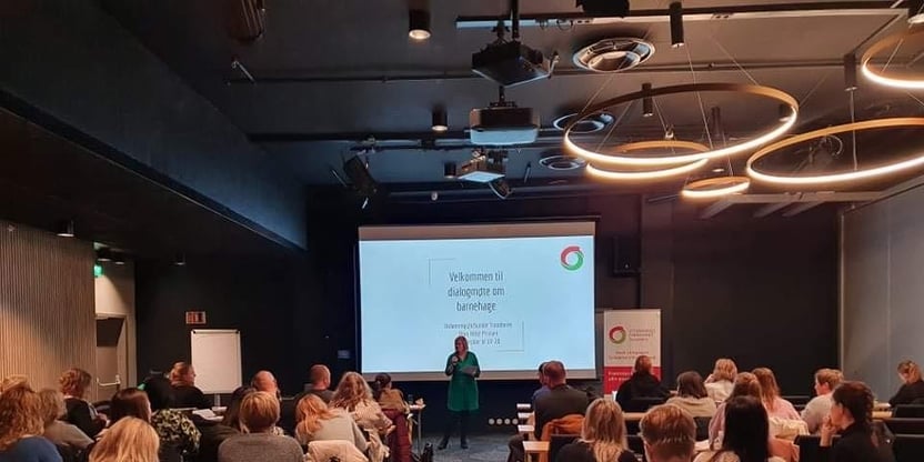Gruppe og foredragsholder i konferansesal