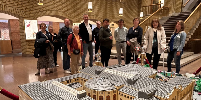 Fylkesstyret Utdanningsforbundet Finnmark poserer foran Legomodell av det norske Storting, inne på Stortinget.