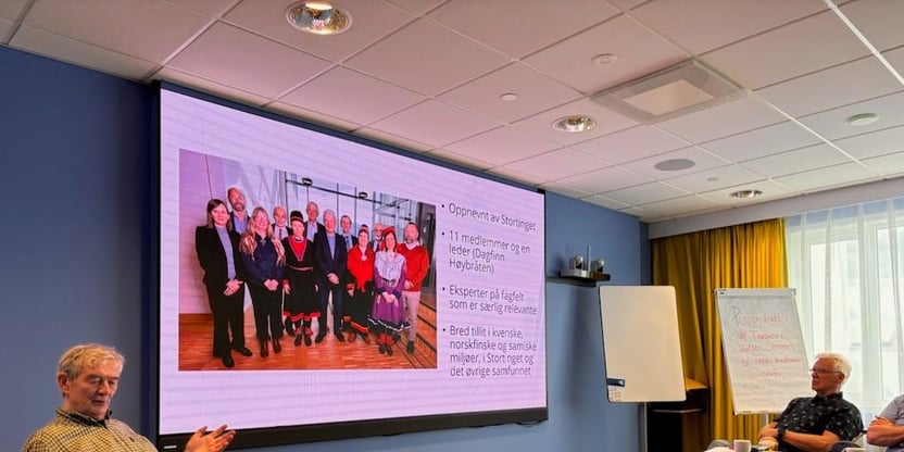 Bilde av Ivar Bjørklund, oppnevnt medlem til Stortingets Sannhet og forsoningskommisjon. Bjørklund sitter foran i møterom, med laptop på et bord. på skjermen bak ham bilde av Sannhets og forsoningskommisjonens medlemmer. Til høyre i rommet en av pensjonistrådet som følger med på skjermen. Bildet er tatt ifm. seminar for penjonistrådskontakter fra lokallagene.