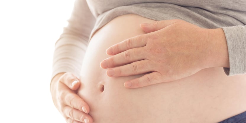 Pregnant woman touching and rubbing her belly
