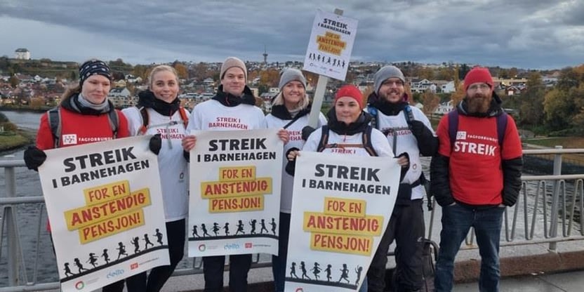 Sju streikende fra Utdanningsforbundet og Fagforbundet med plakater og t-skjorter med påskriften "Streik i barnehagen - for en anstendig pensjon!" Foto.