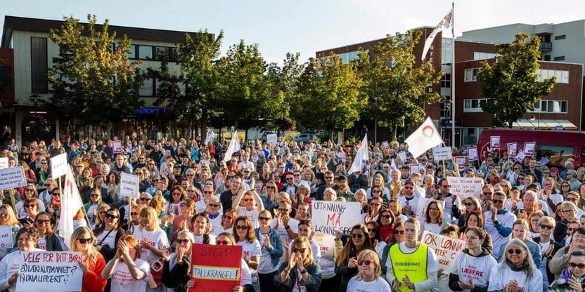 Mer enn 500 mennesker samlet på torget i Stjørdal, noen kledd i streike-t-skjorter, noen med faner og plakater.