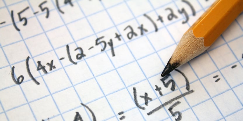 Foto av en del av en matematikkutregning, papir og blyant