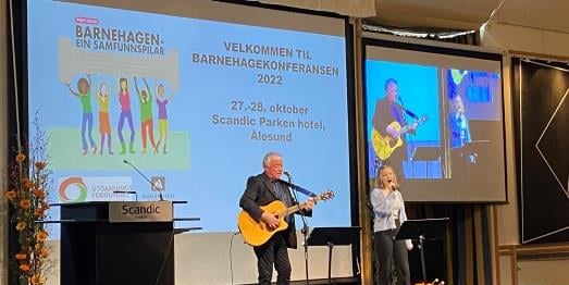 Kulturelt innslag med en kvinne på vokal og en mann på gitar.