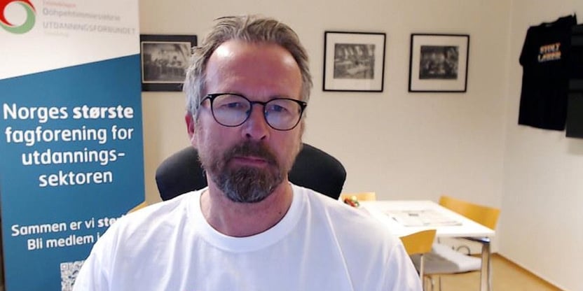 Fylkesleder Geir Røsvoll ikledd hvit tskjorte med påskriften "Streik i barnehagen". Bakgrunn kontormiljø, med rollup med teksten "Norges største fagforening for utdanningssektoren". FOTO