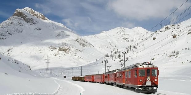 Rødt tog i snølandskap. Foto.