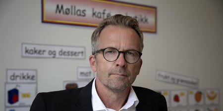 Bildet viser hodet til Geir Røsvoll. I bakgrunnen ser vi plakater fra en barnehage eller barneskole.