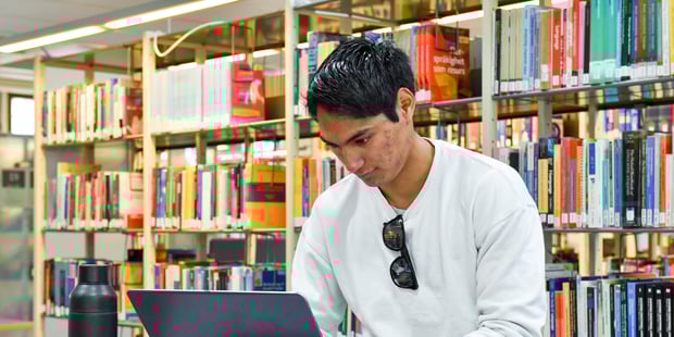 Student på biblioteket på universitetet / høyskolen. Illustrasjonsfoto