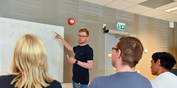 Bilde av mannlig lærer som underviser studenter i matematikk