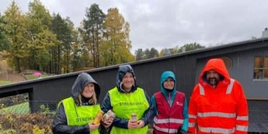 Vi ser 4 personer på streikevakt i regnvær.
