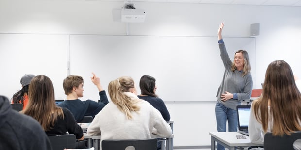 Foto av kvinnelig lærer foran skoleklasse