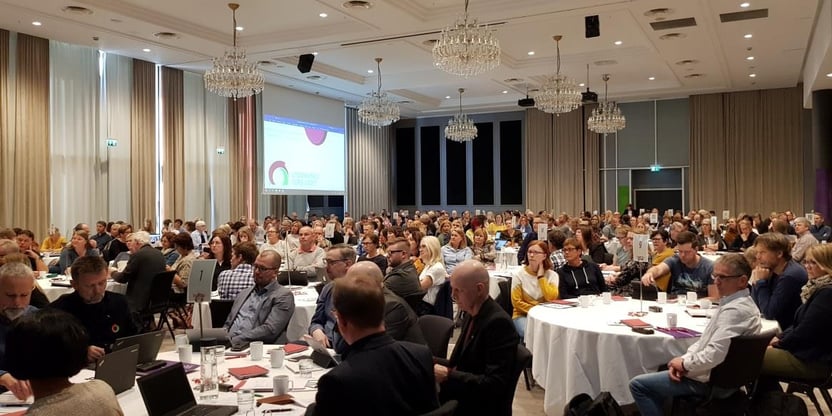 Bilde fra fylkesstyremøtet i Utdanningsforbundet Trøndelag i 2019. Representanter sitter rundt flere bord i en stor konferansesal. FOTO.