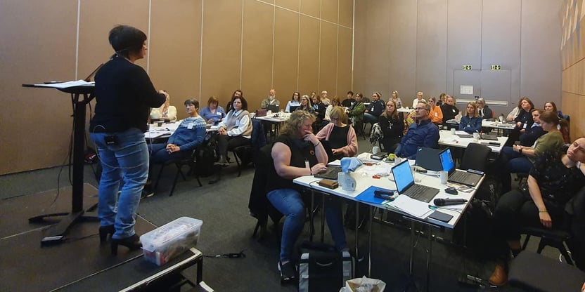 Gerd står på talestol foran en forsamling mennesker, som er samlet i Trondheim. 