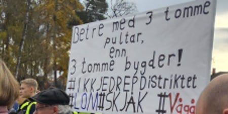 Bilde av plakat fra markeringen på Hamar med påskriften: Betre med 3 tomme pulter enn 3 tomme bygder