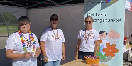 Tre kvinner på stand under pridearrangement på Torvet i Kristiansand.