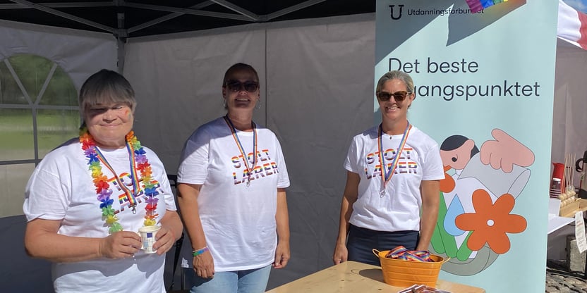 Tre kvinner på stand under pridearrangement på Torvet i Kristiansand.