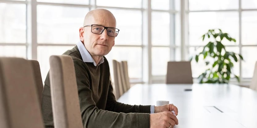 Steffen Handal sitter ved et møtebord og ser mot kamera.