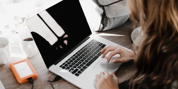 Bilde av en person som arbeider på en laptop