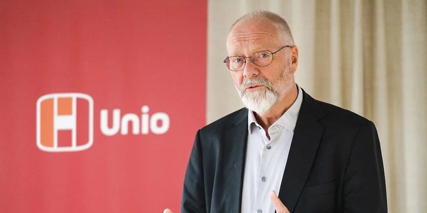Spesialrådgiver Erik Orskaug i Unio står foran Unio-logo iført dressjakke og ser mot kamera.