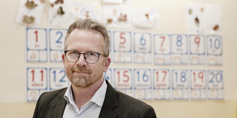 Nærbilde av Geir Røsvoll, leder i Utdanningsforbundet fra 01.01.24. Smiler forsiktig, lukket munn. Inne i et klasserom.