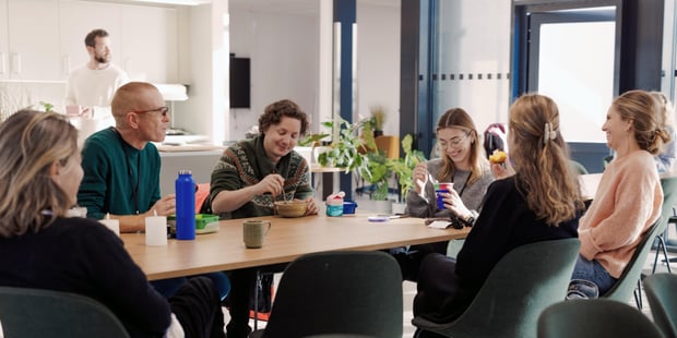 Bildet viser lærere ved Oksenøya barneskole. Vi er inne i lærerværelset, hvor det er lunsjpause. Det er god stemning og lærerne smiler.