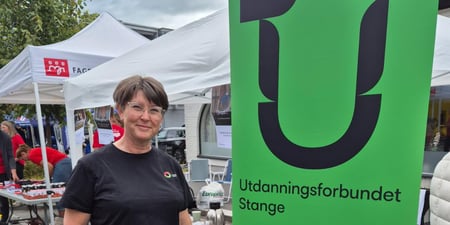 Kvinne står på stand ved siden av Utdanningsforbundets logo