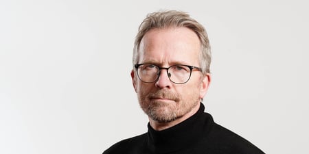 Bildet viser Geir Røsvoll fra halsen og opp. Han ser streng ut.