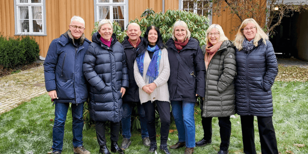 Pensjonistrådets medlemmer står på en rekke i fint novemberlys, i bakgården til Hornemannsgården.
