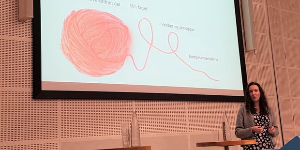 Foto av Marte Balas foran en skjerm med power point. Motivet på skjermen er en rød tråd