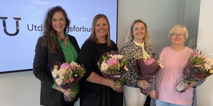 Fire kvinner som står med hver sin blomsterbukett i hånda.