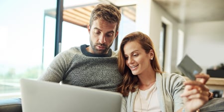 to personer sitter og holder rundt hverandre mens de ser på en pc.