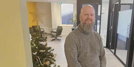 Bilde av Thore Johan Nærbøle, sittende på en krakk ved siden av et juletre