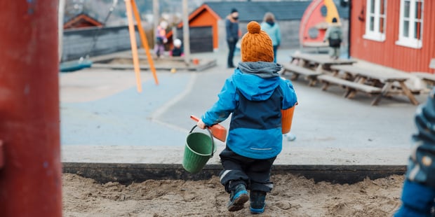 Uteområde i barnehagen, Noen barn, et par voksne, Sandkasse, Uteleke,r Ser litt av barnehagehuset.