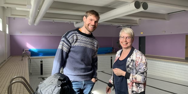 Nils Kristen Sandtrøen, stortingsrepresentant for Arbeiderpartiet, og leder i Utdanningsforbundet Stor-Elvdal, Mari Kværnes, i godt humør foran et nitrist syn av et tomt basseng.